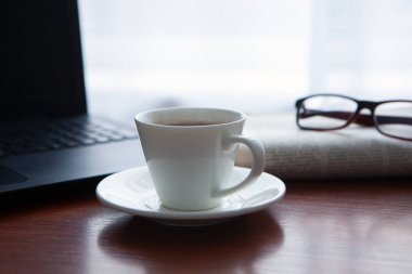 Masada bilgisayar olan bir gazete. Kahve molası.