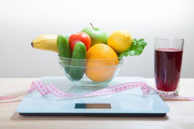 Sağlıklı beslenme, vücut geliştirme ve kilo verme konsepti, meyve, sebze. Ölçü bandı olan kız.