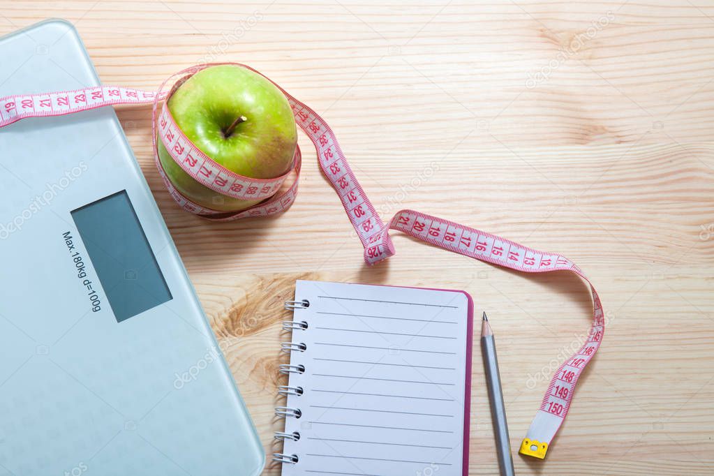 The concept of a healthy diet, fitness and weight loss. Fruits, vegetables, scales, measuring tape on the table.