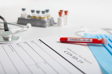 Dünya koronavirüs salgını konsepti. Salgın COVID 19, 2019-NKoV. Coronavirus aşısı testi. Pozitif analiz ve laboratuvar kan örneği. Test tüpü, aşı, maske.
