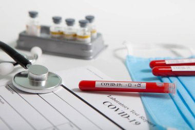 Dünya koronavirüs salgını konsepti. Salgın COVID 19, 2019-NKoV. Coronavirus aşısı testi. Pozitif analiz ve laboratuvar kan örneği. Test tüpü, aşı, maske.
