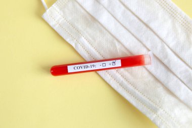 Dünya koronavirüs salgını konsepti. Salgın COVID 19, 2019-NKoV. Coronavirus aşısı testi. Pozitif analiz ve laboratuvar kan örneği. Test tüpü, aşı, maske.