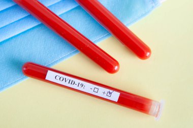 Dünya koronavirüs salgını konsepti. Salgın COVID 19, 2019-NKoV. Coronavirus aşısı testi. Pozitif analiz ve laboratuvar kan örneği. Test tüpü, aşı, maske.