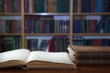 Kitaplar ve bir fincan kahveyle rahatlama anları. Eski kitaplar, gözlükler, sandalye, kütüphane