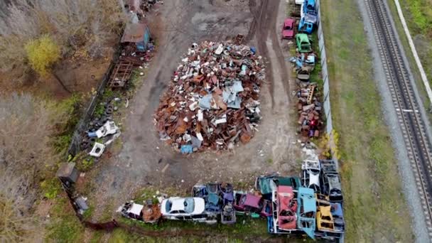 Voo aéreo sobre um pequeno armazém para reciclagem de carros antigos. Tomado por drone — Vídeo de Stock