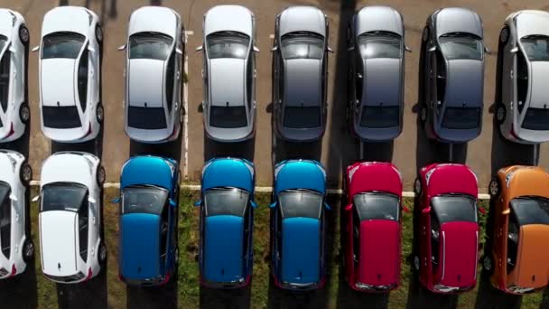 Voar aéreo sobre carros multi-coloridos em pé em um estacionamento. Tomado por drone — Vídeo de Stock