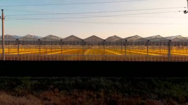 Seranın şeffaf duvarından uzağa uçuyor. Gün batımından sonra insansız hava aracı tarafından çekildi.