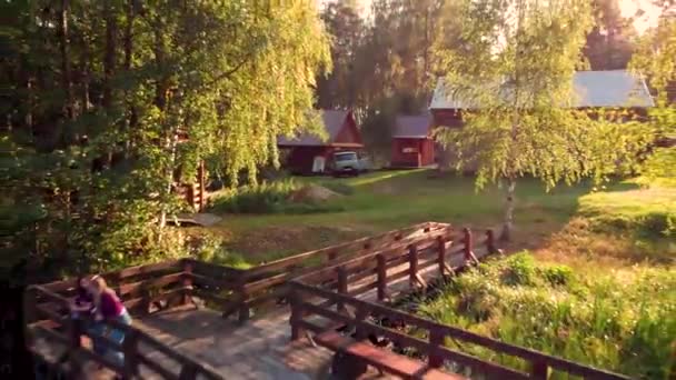 Vol aérien au-dessus d'un petit lac forestier depuis un pont en bois. Pris par drone — Video