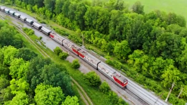 Luchtopname van goederentrein die per spoor reist. Ingenomen door drone bij zonsondergang — Stockvideo