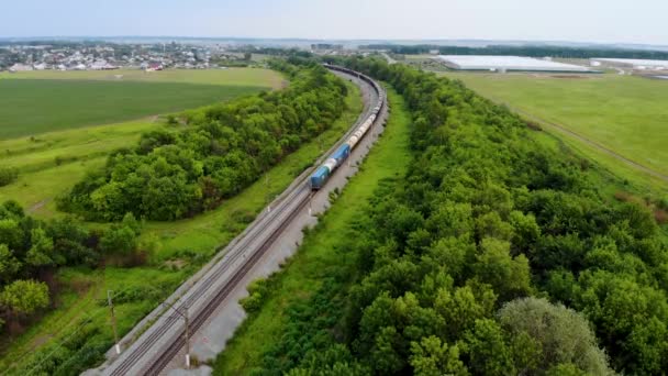 Luchtopname van goederentrein die per spoor reist. Ingenomen door drone bij zonsondergang — Stockvideo