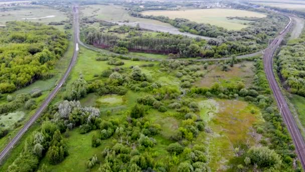 Vue aérienne d'une jonction ferroviaire reliée par un chemin de fer arrondi — Video