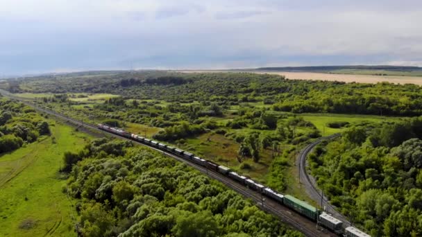 Luchtopname van goederentrein die per spoor door een spoorwegovergang rijdt — Stockvideo