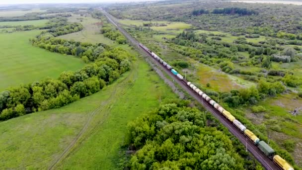 Аэросъемка грузового поезда, проходящего по железной дороге через железнодорожную развязку — стоковое видео