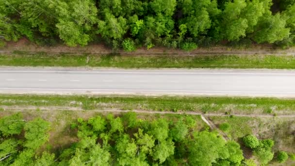 Повітряний безпілотник летить по шосе, на якому проходить вантажівка в літній день — стокове відео