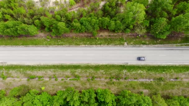 Légi drónrepülés az autópálya felett, amelyen egy autó a nyári napon — Stock videók