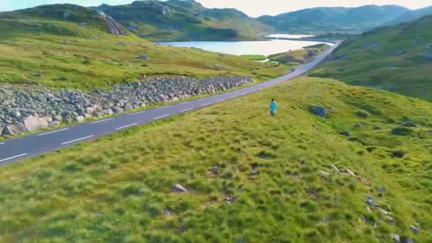 Aereo drone volo intorno a una ragazza che va su una collina in mezzo a una valle — Video Stock