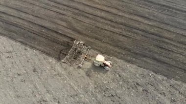 Çernozem alanını bozan bir traktörün hava aracı görüntüsü. Baharda çekildi.