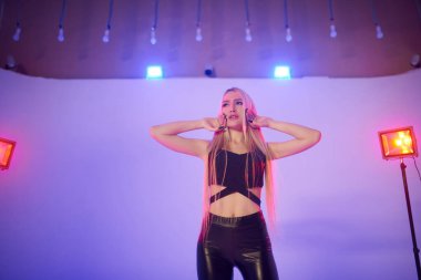 Pembe sahnede güzel bir sarışın. Güzel bir kızla fotoğraf çekimi.