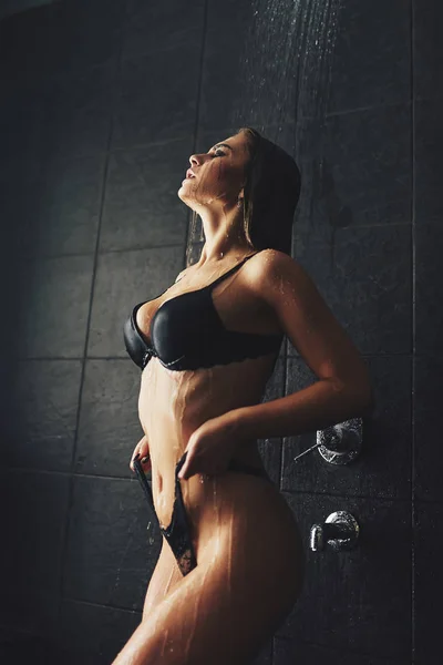 Güzel bir kız duşta duruyor. Islak fotoğraf çekimi. — Stok fotoğraf