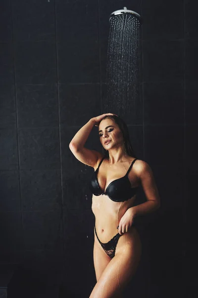 Er staat een mooi meisje onder de douche. Natte fotoshoot — Stockfoto