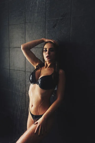 Ein schönes Mädchen steht unter der Dusche. Nasses Fotoshooting — Stockfoto