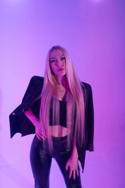 Pembe arka plan üzerinde iskemlede çekici sarışın kadın