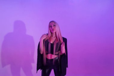 Pembe arka plan üzerinde iskemlede çekici sarışın kadın