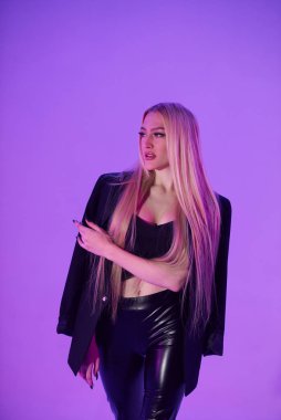 Pembe arka plan üzerinde iskemlede çekici sarışın kadın