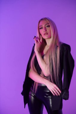 Pembe arka plan üzerinde iskemlede çekici sarışın kadın