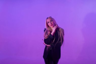 Pembe arka plan üzerinde iskemlede çekici sarışın kadın