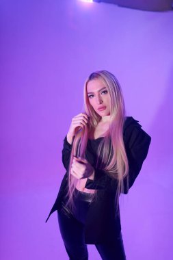 Pembe arka plan üzerinde iskemlede çekici sarışın kadın