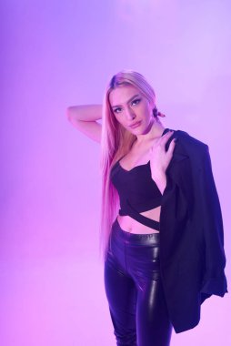 Pembe arka plan üzerinde iskemlede çekici sarışın kadın