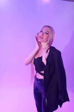 Pembe arka plan üzerinde iskemlede çekici sarışın kadın