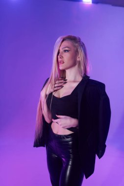 Pembe arka plan üzerinde iskemlede çekici sarışın kadın