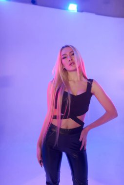 Pembe arka plan üzerinde iskemlede çekici sarışın kadın