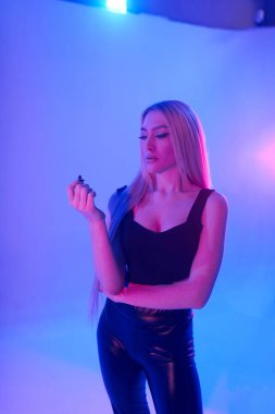 Pembe arka plan üzerinde iskemlede çekici sarışın kadın