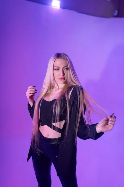 Atractiva mujer rubia sentada en la silla sobre fondo rosa — Foto de Stock