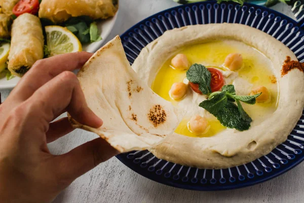 Hummus Auf Einem Teller Die Hand Hält Fladenbrot Isst — Stockfoto