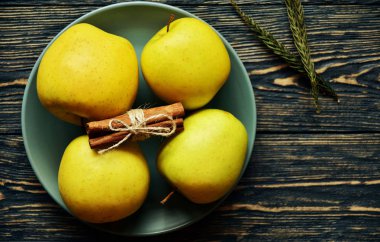 Olgun sarı elmalar ve tarçınlı çörekler. Koyu ahşap arka plan. Üst Manzara. Durgun hayat. Doğal ışık.