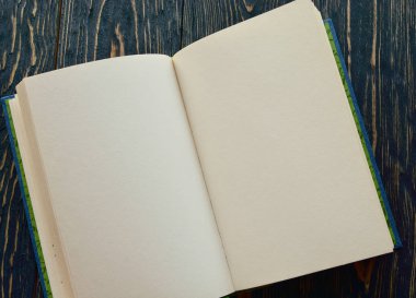Koyu ahşap arka planda açık bir kitap. Üst Manzara. Yakın plan. Düz yatıyordu.