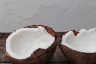 Tahta bir masada hindistan cevizinin iki yarısı.