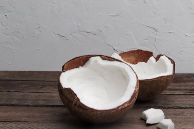 Tahta bir masada hindistan cevizinin iki yarısı.