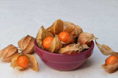 Beyaz arka planda bir kasede fizsalis.