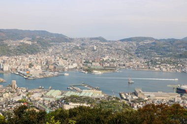 Güneşli bir günde Nagasaki şehrinin, mavi gökyüzünün ve dağların olduğu İnasa Dağı 'nın manzarası.
