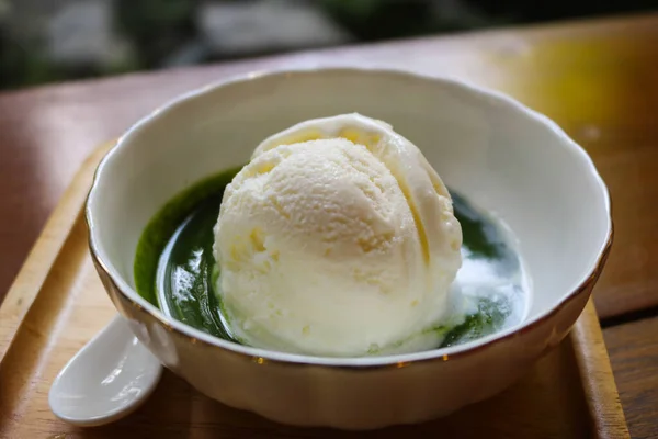 Hokkaido milk ice-cream with matcha green tea sauce on wood plate, Japanese ice-cream dessert style