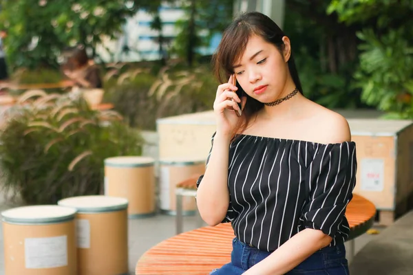 Portret Zmartwionej Azjatki Rozmawiającej Przez Telefon Podczas Siedzenia Parku Problemy — Zdjęcie stockowe