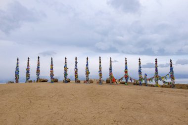 Burhan Burhan Burnu, Baykal, Olkhon Adası, Sibirya, Rusya 'da renkli kurdeleli Şaman ahşap ayin totemleri.