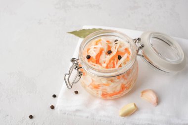 Cam kavanozdaki lahana turşusu masanın üstünde havlunun üzerinde..