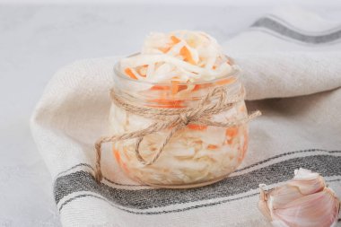 Probiyotik gıda konsepti. Açık gri mutfak masasında siyah biberli şeffaf lahana turşusu..