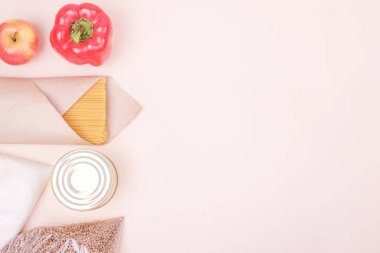 Karabuğday, şeker, konserve yiyecek, bej arka planda sebzeler. Boşluğu kopyala, üst görünüm.